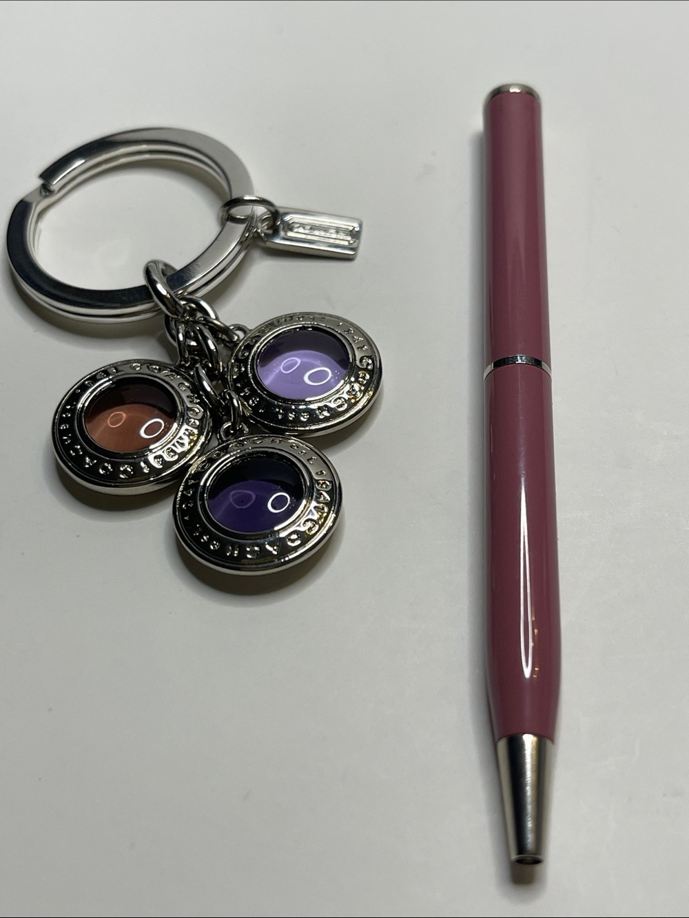 Coach Silver Circle Charm Keychain with Purple and Pink Accents and a Coach Pen
